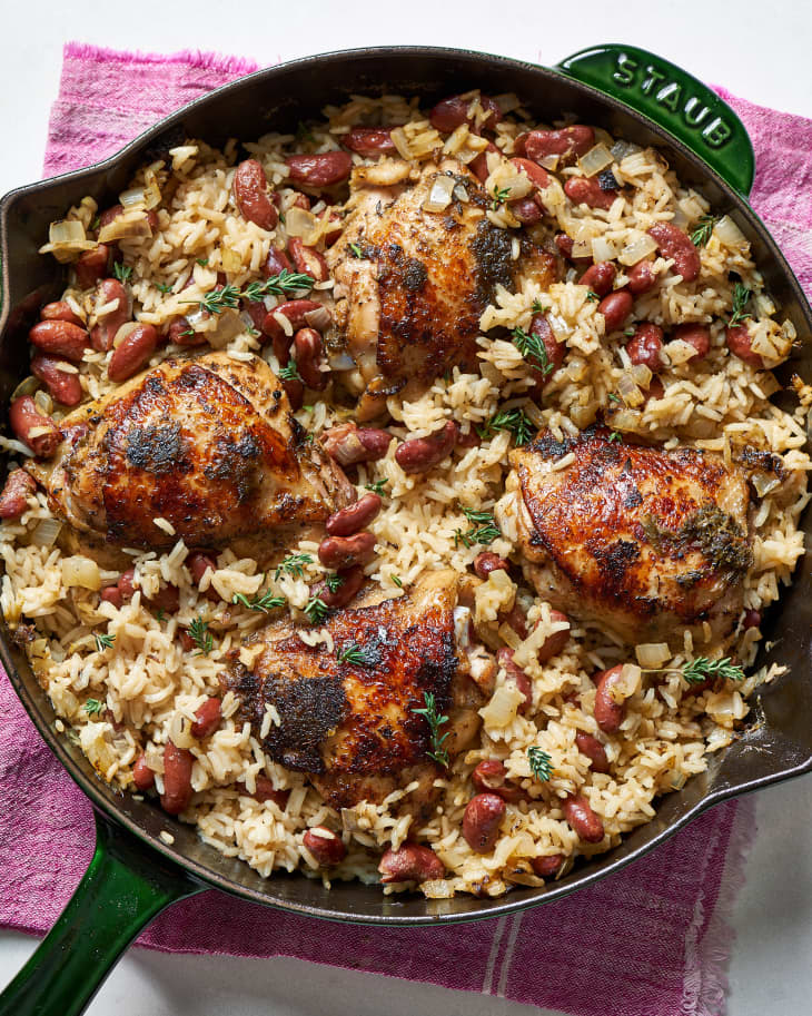 Jerk chicken cooked in coconut milk and vinegar with rice and garnished with herbs