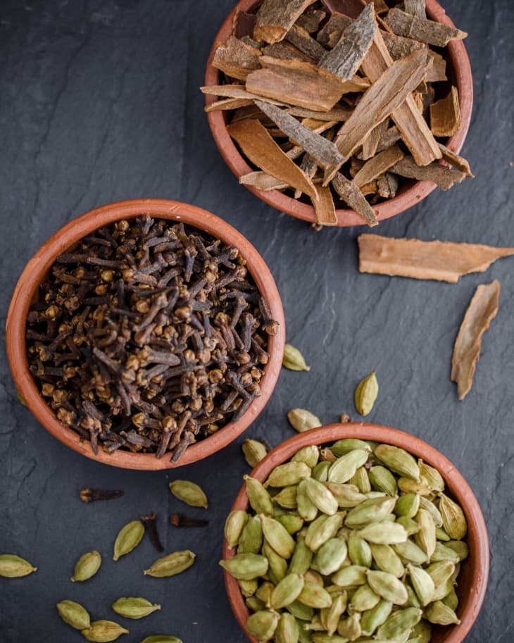 A set of small spice jars full with various colorful Indian