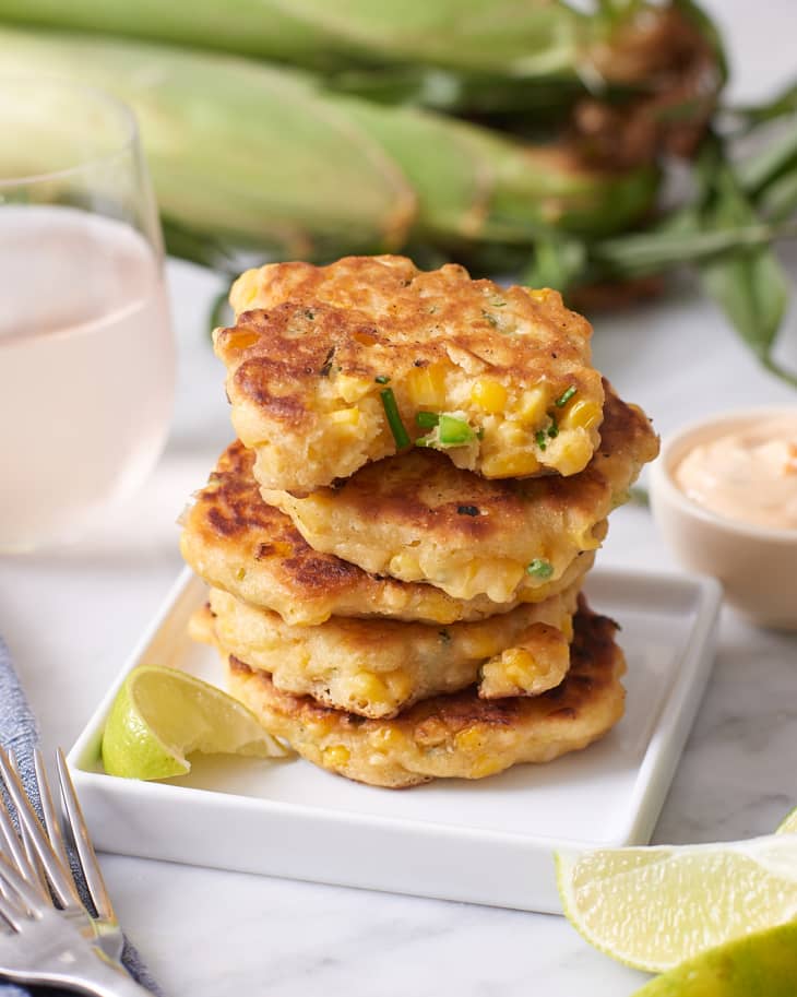 A stack of corn fritters on a square plate