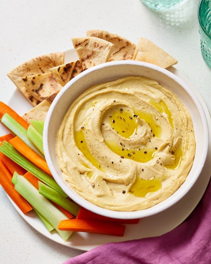 Hummus with pita bread, sliced carrots and celery on the side