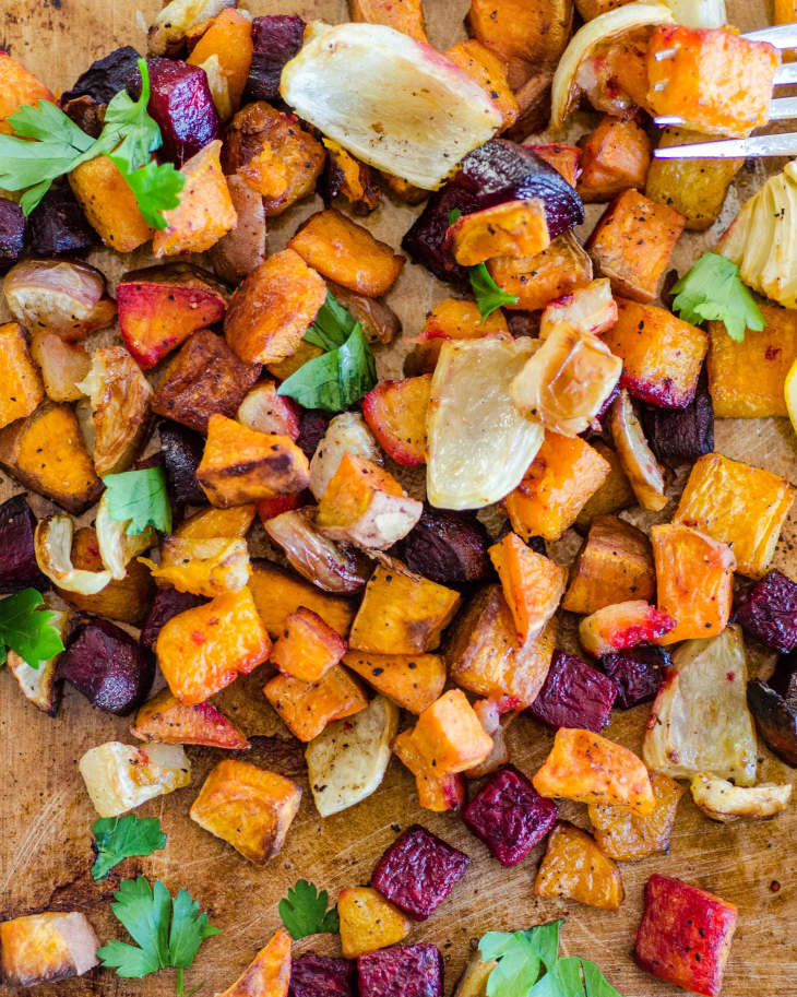 Roasted vegetables spread on a wood cutting board