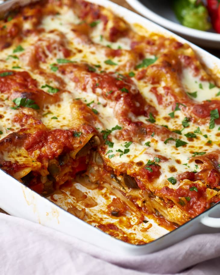 A baking dish of lasagne with a slice cut out showing the cross section