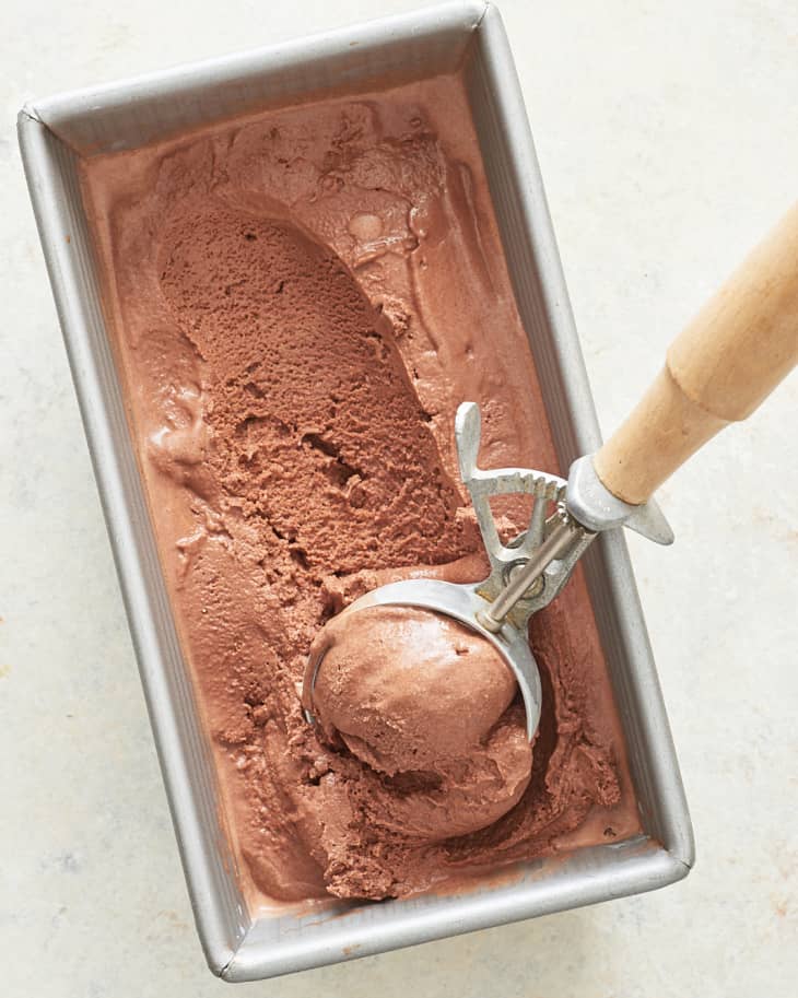 Chocolate ice cream is scraped onto an ice cream scoop