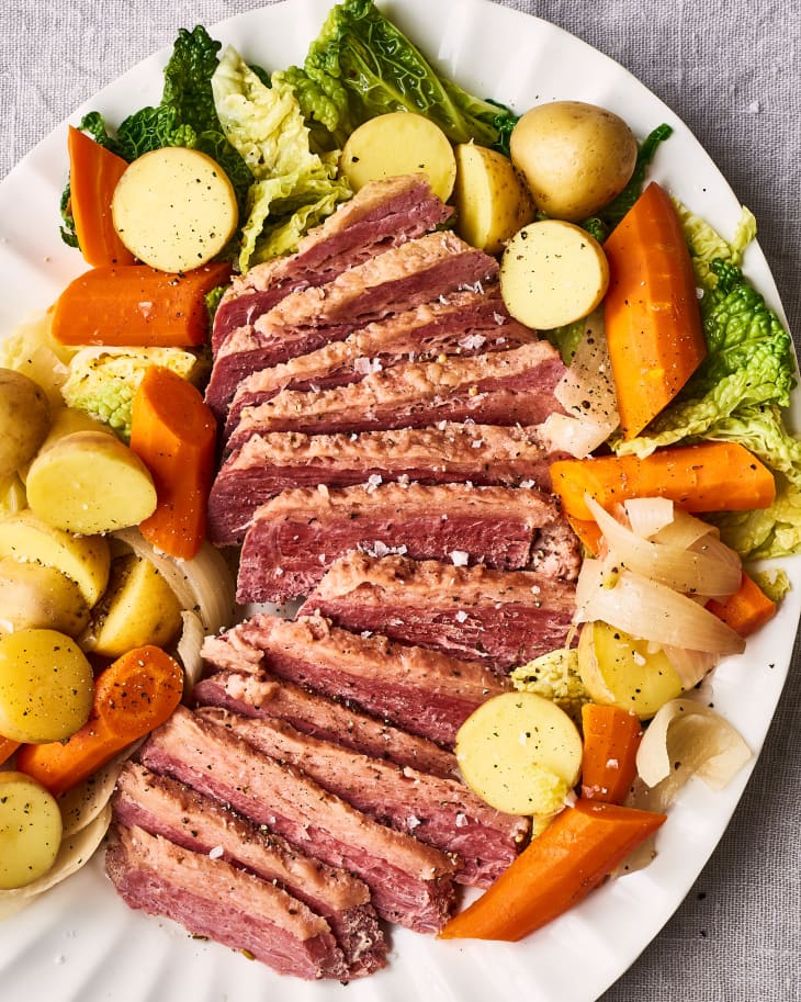 Platter filled with sliced corned beef with potatoes, carrots, and cabbage.