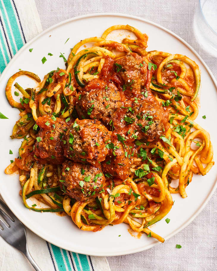 A plate of Italian meatballs in sauce over spaghetti