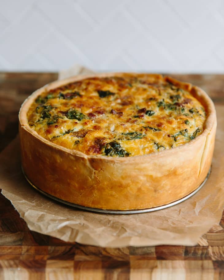 Deep-dish quiche lorraine with Swiss chard and bacon set on a parchment paper