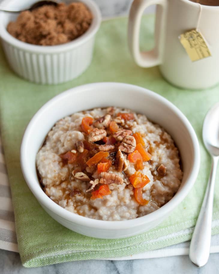 A bowl of oatmeal made from steel-cut oats, topped with chopped fruit and nuts