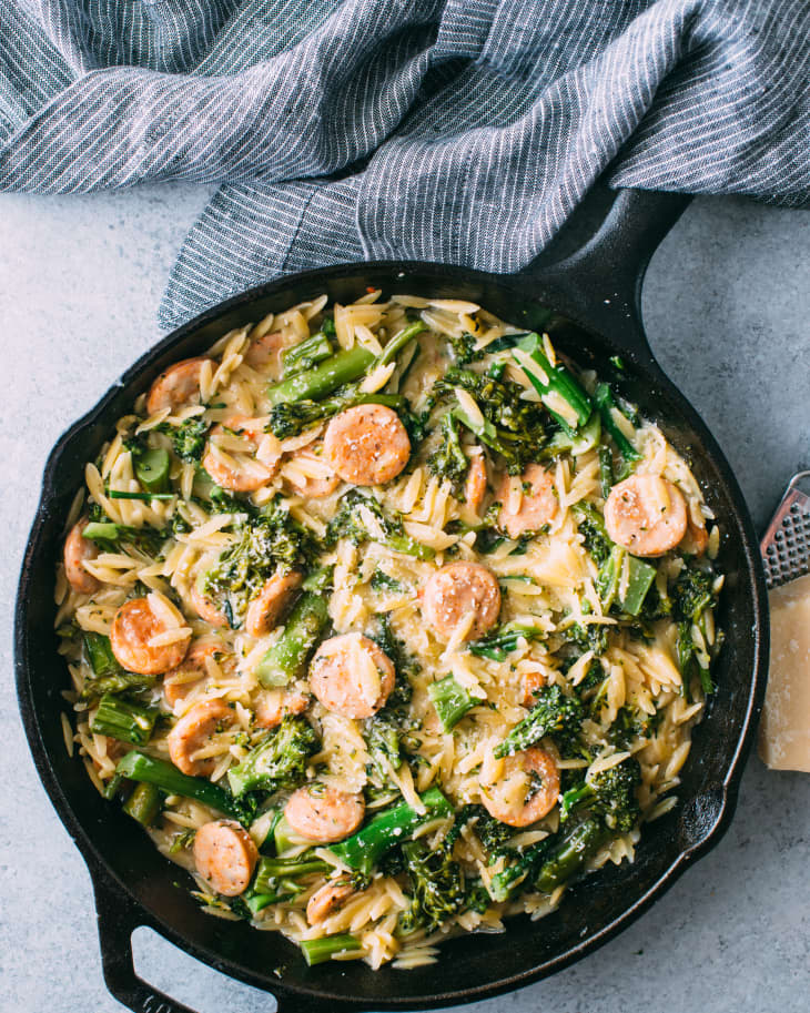 Chicken sausage with orzo and broccoli rabe in a cast iron pan