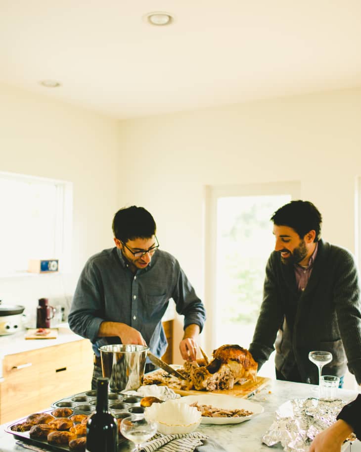 Family Using Gadgets Whilst Eating Breakfast Together In Kitchen