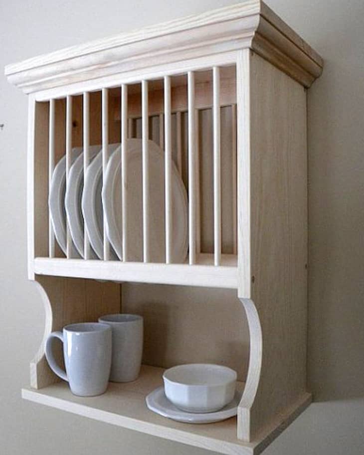 Dish Rack Holds Many Dishes And Cups Against Wooden Countertop