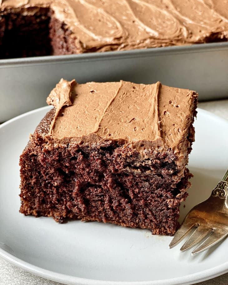 Slice of Aunt Doris's Chocolate Cake on plate with fork, rest of cake in pan in background