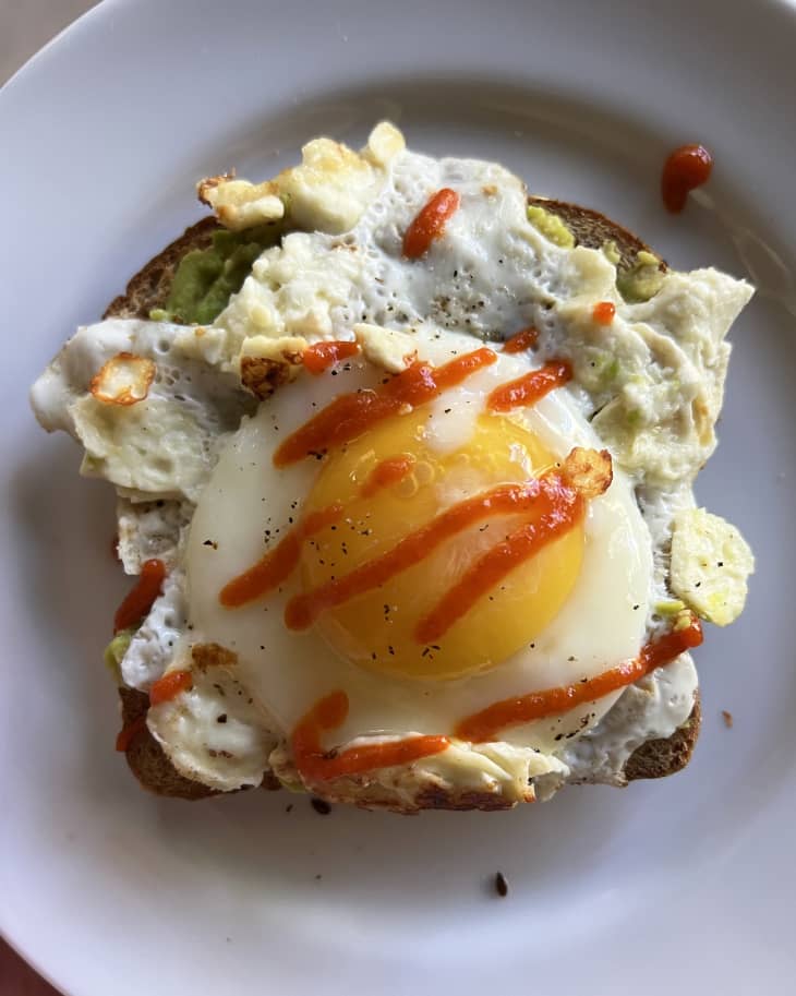 feta-fried egg with sriracha drizzle on white plate