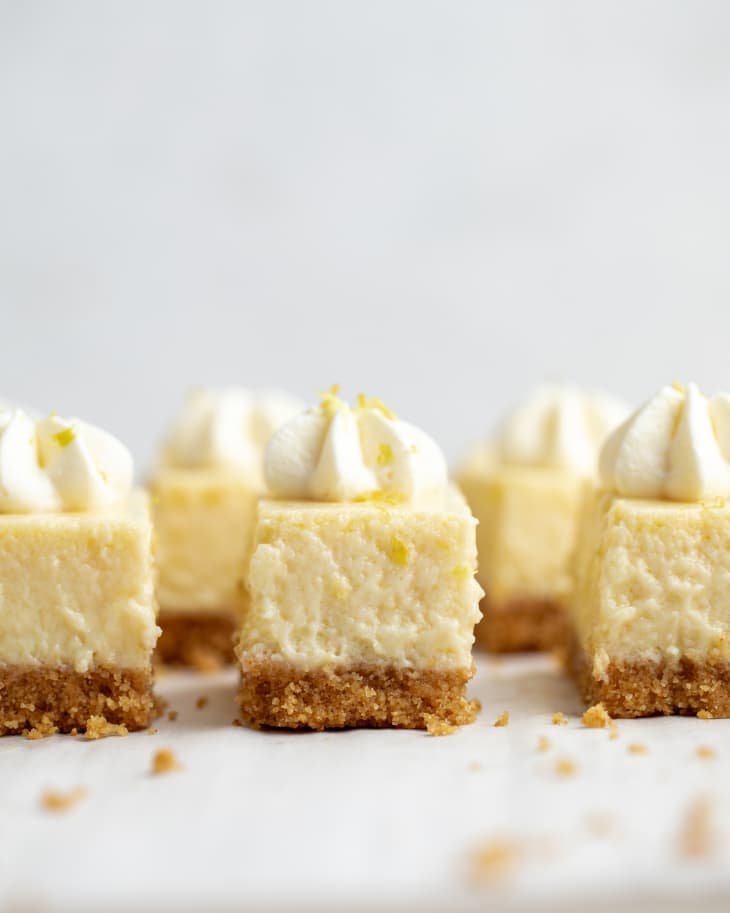 dollop of whipped cream, yellow square bars, cut in rows, graham cracker crust, crumbs