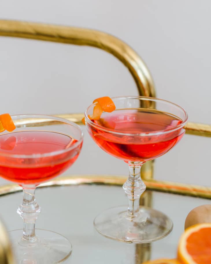 Gold Bar Cart with Pink Cocktails on it and oranges peeled open
