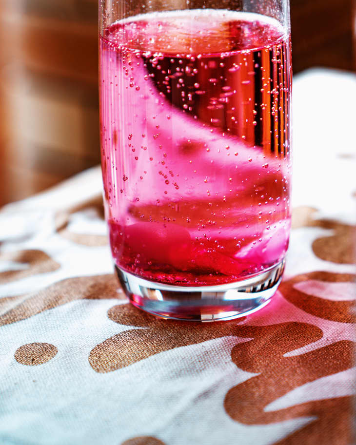 Colourful Sparkling Water in the Glass on a Table Cloth with Golden Letters