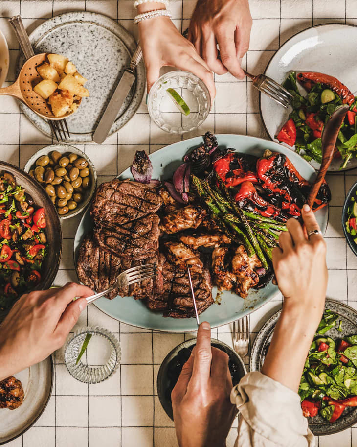 Flat-lay of people having barbeque party with meat and vegetables