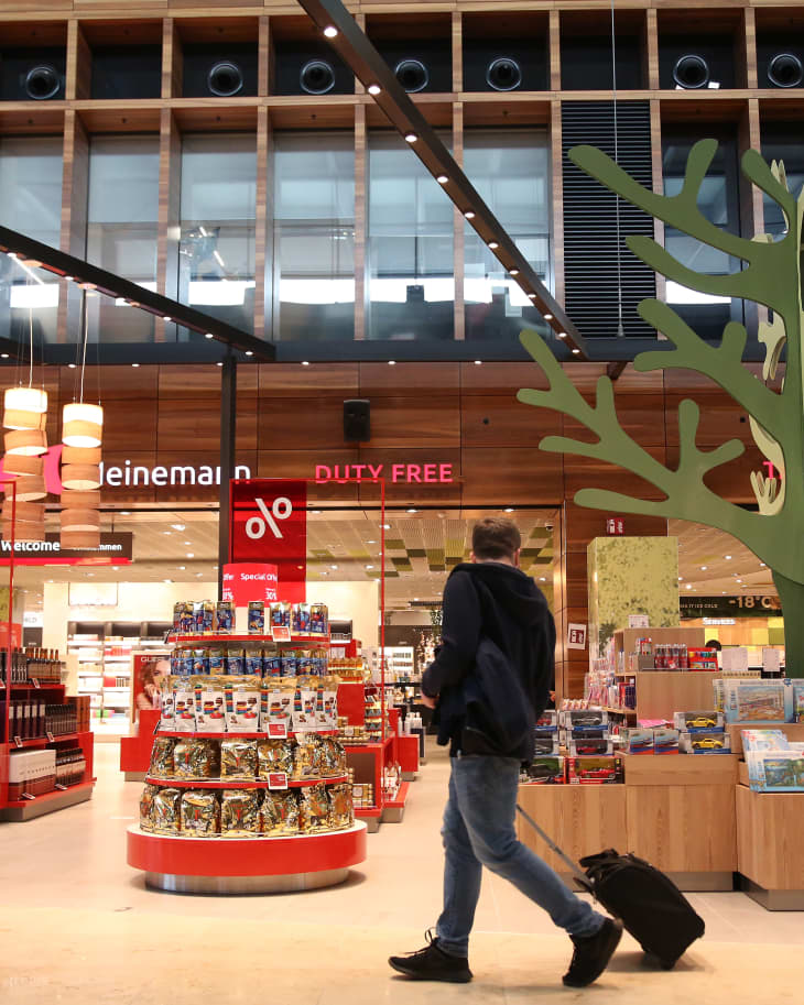 A passenger looks at items as he passes a duty-free store in a shopping area on the first full day of public operation of the new BER Berlin Brandenburg Airport on November 1, 2020 in Schoenefeld, Germany. The new airport incorporates former Schoenefeld airport as its Terminal 5 and also replaces Tegel Airport, which will close in the coming days. Berlin Brandenburg Airport was originally scheduled to open in 2011 but was stricken by design flaws, corruption scandals, legal wranglings and failed technical audits. The airport will serve Berlin and the surrounding region.