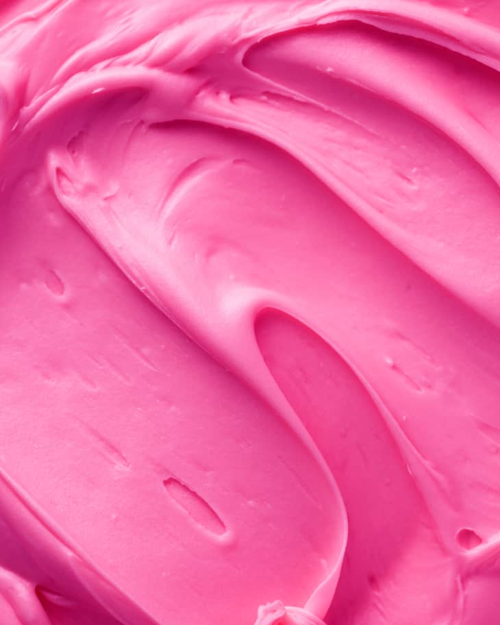 Vibrant pink buttercream frosting close up texture