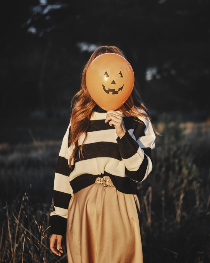 A woman is behind a halloween balloon