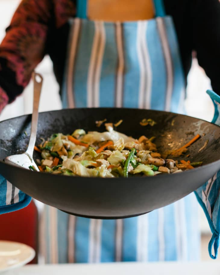 A spatula for stirring food picks off burnt food in a pan. Poor