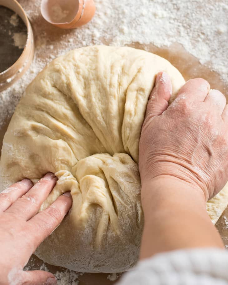 Woman kneading dough in kitchen