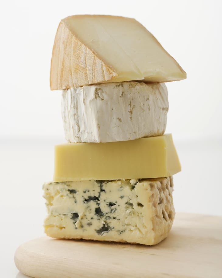 Stacked blocks of cheese on cutting board
