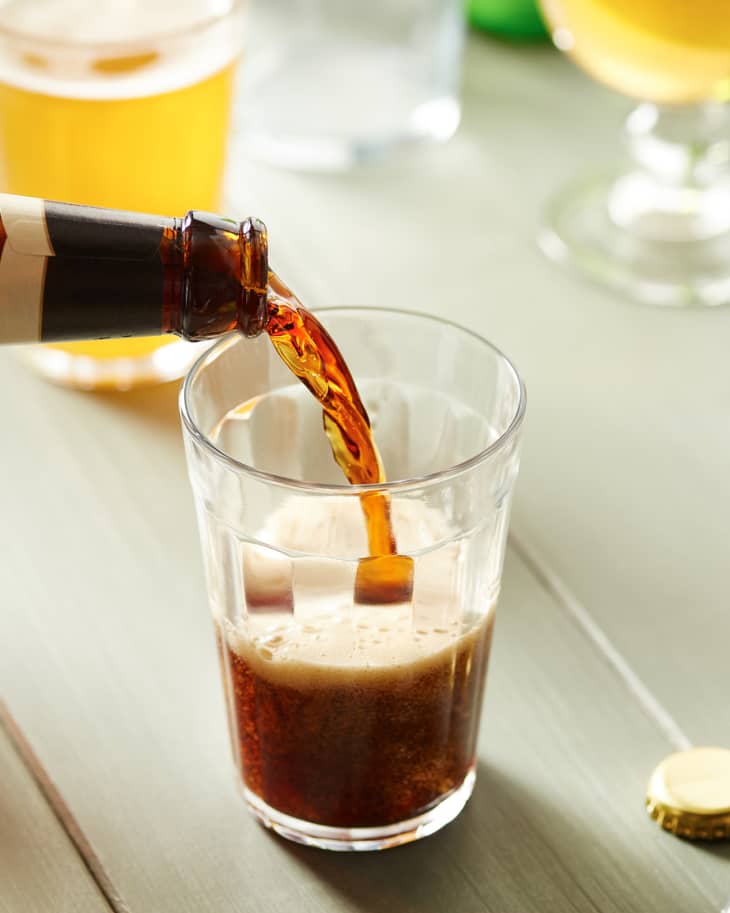 Pouring bottled beer into glass.