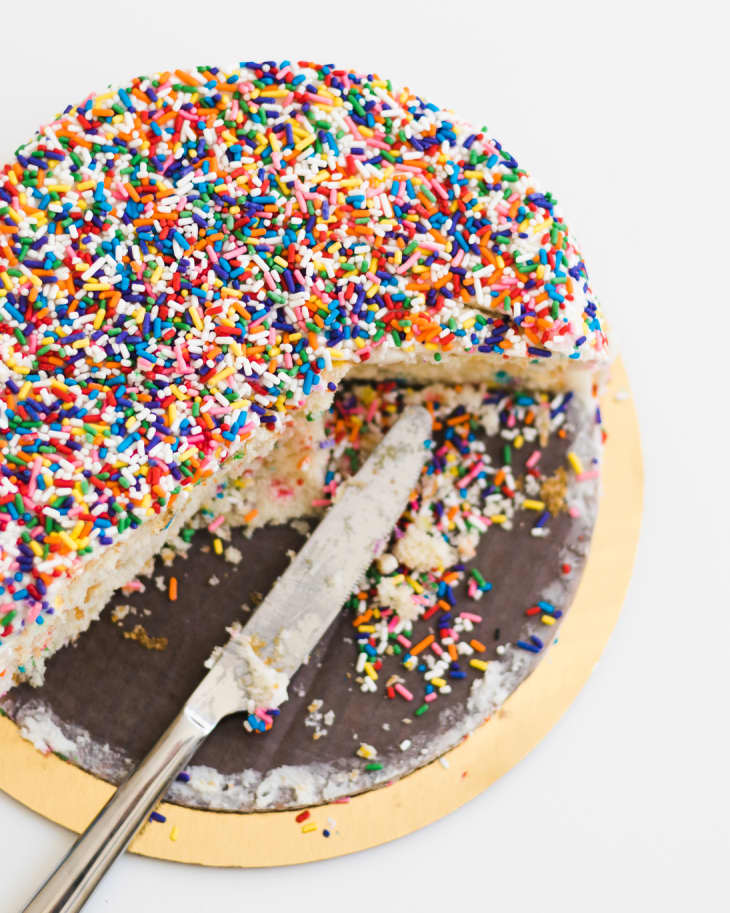 Half eaten funfetti birthday cake covered in sprinkles