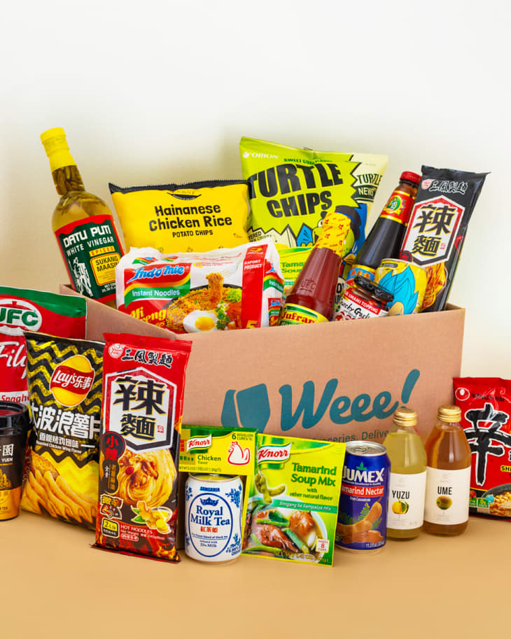 Asian guy organizing boxes with supplies on shelves Stock Photo by