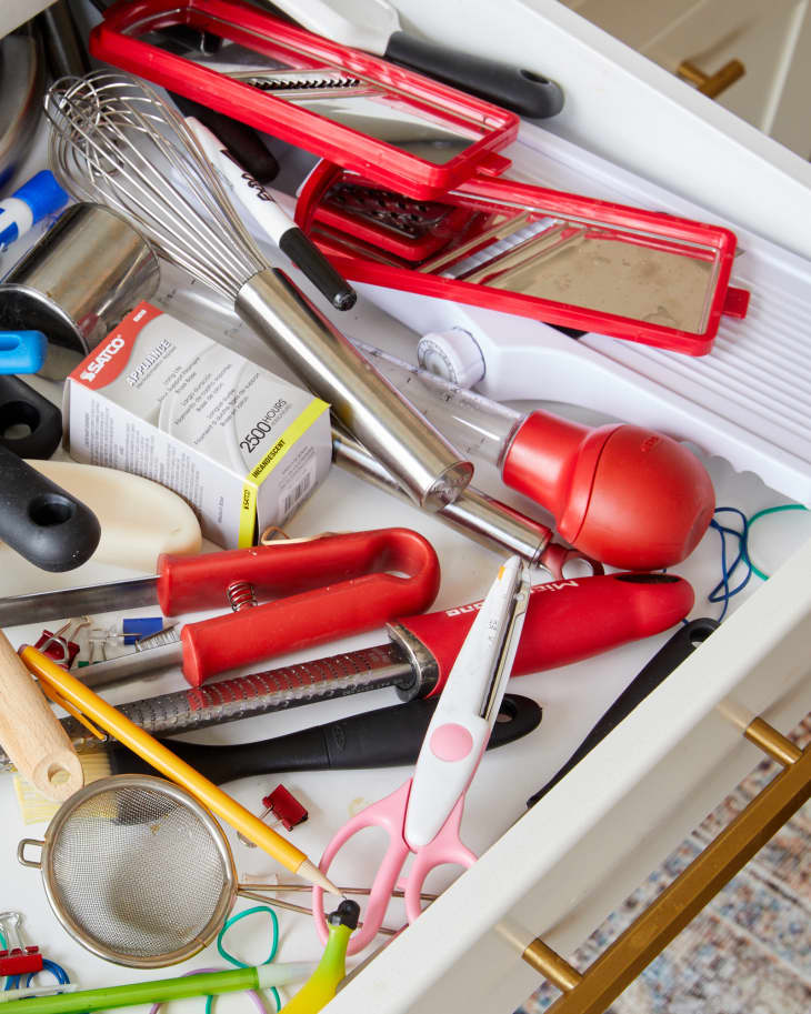 Interior of messy kitchen drawer (junk drawer)
