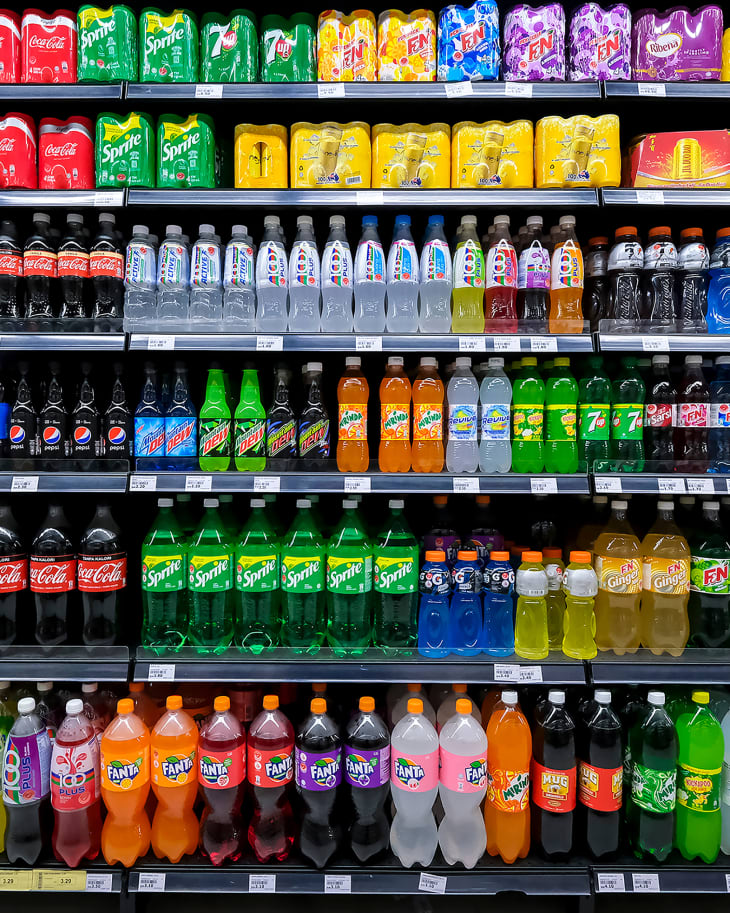 Variety of energy drinks, soda, soft drinks, with various brands product in bottles and cans on the shelves in a grocery store supermarket.