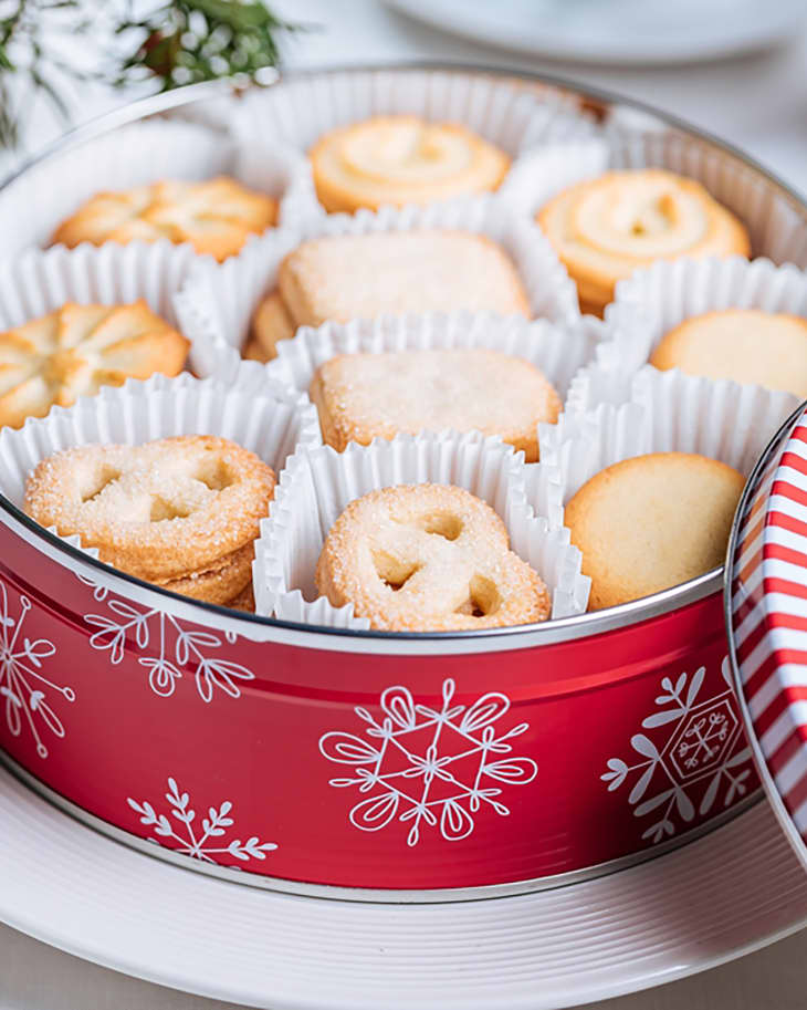 Danish butter cookies in a red Christmas tin box with the snowflakes and deer illustration. Holiday tea cake cookies.