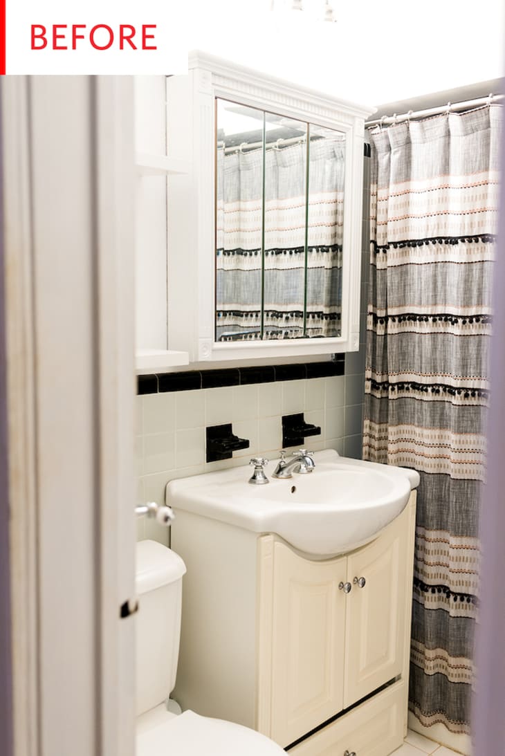 Small bathroom with mirrored cabinet, beige vanity, and striped shower curtain.