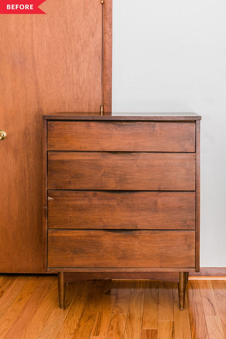 Mid-century modern wooden dresser with four drawers on a hardwood floor.