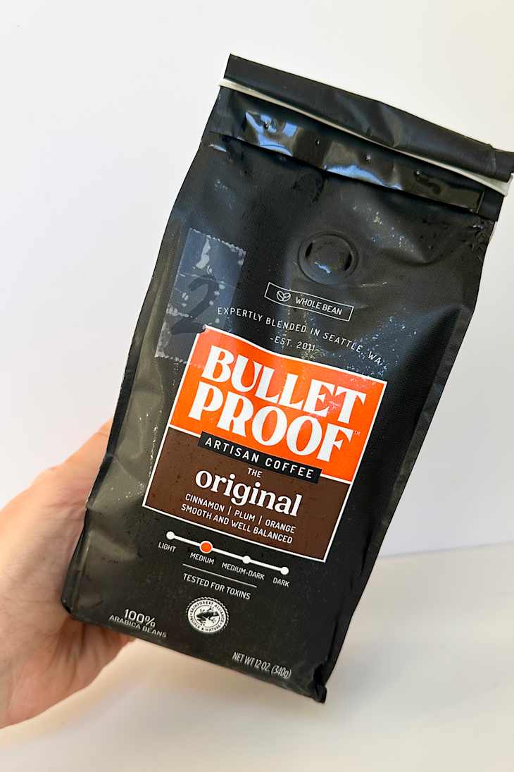 Whole bean coffee bag labeled "Bulletproof Original" with flavor notes of cinnamon, plum, and orange.