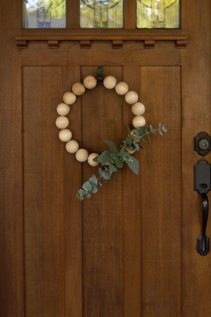 beaded wood wreath on a wood door
