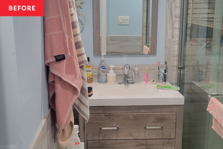 Before: a blue bathroom with wooden drawers under the sink