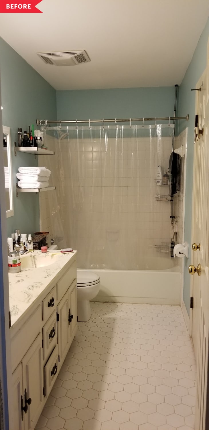 Bathroom with hexagonal tile floor, marble countertop, white cabinets, and a shower with a clear curtain.