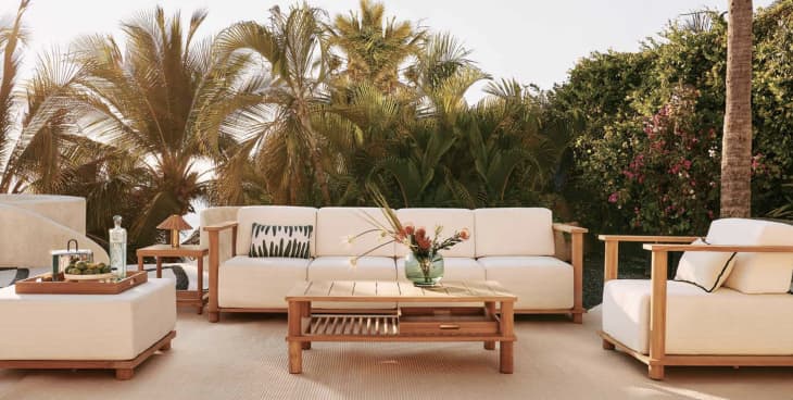 Teak and cream upholstered outdoor sofa, ottoman, chair, and coffee table from the CB2 and Ross Cassidy collection