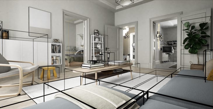 Modern living room with gray sofa, wooden coffee table, bookshelves, and a large plant, leading to a kitchen and bedroom.