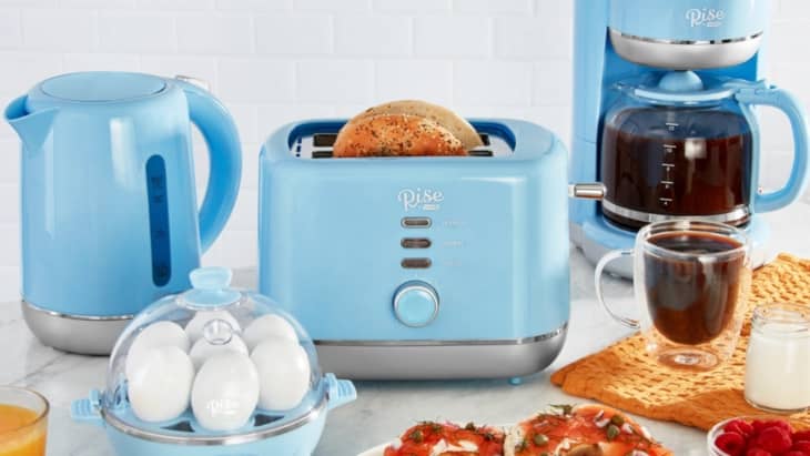 Blue kitchen appliances set with kettle, toaster, coffee maker, and egg cooker on a countertop.