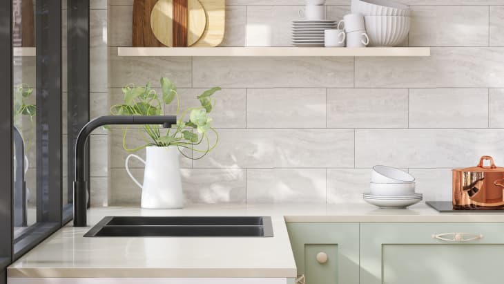 Minimal and cozy green kitchen counter with white laminated plastic top and black quartz sink with sunlight from window on wall for product display