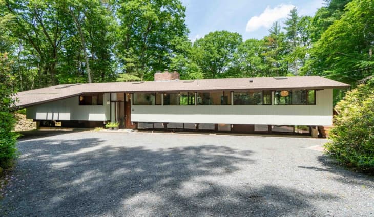 long and low, cement driveway, wide, long windows, angled roof, white exterior, 70's