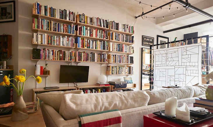 A living room with a large bookcase filled with books.