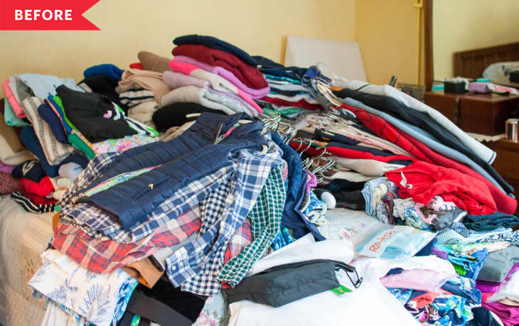 Cluttered bed with piles of clothes, hangers, and a "Before" label in a bedroom.