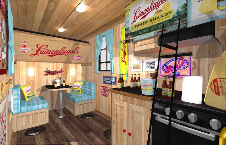 Wood-paneled room with Leinenkugel's decor, blue checkered booth seating, and bottles on a black counter.