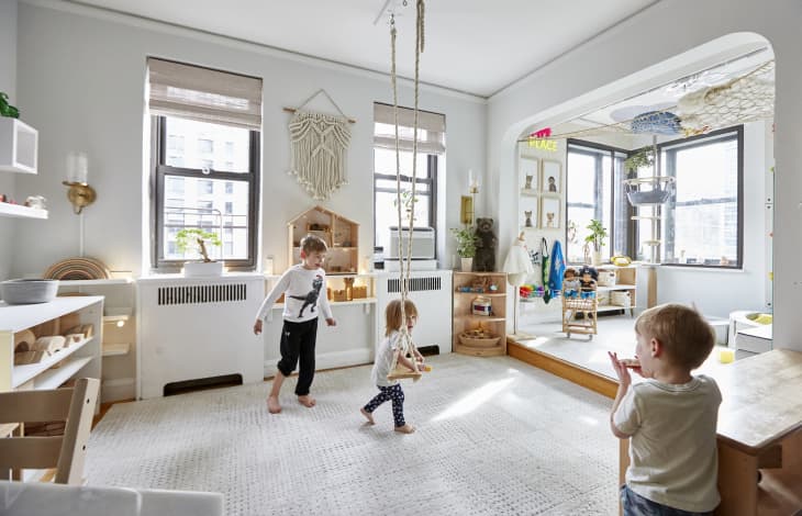 Kids playing on swing set in playroom.