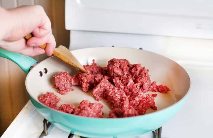 Woman stirring ground beef in a frying pan