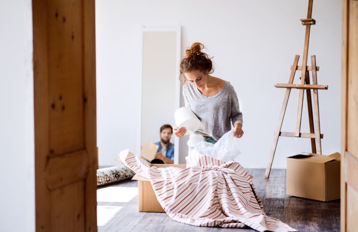 Woman packs lamp into moving box