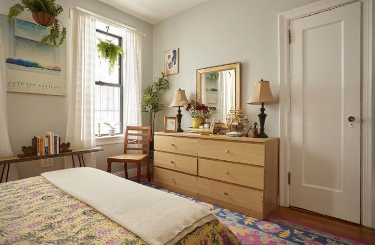 Wooden dresser topped with matching table lamps in Brooklyn apartment.